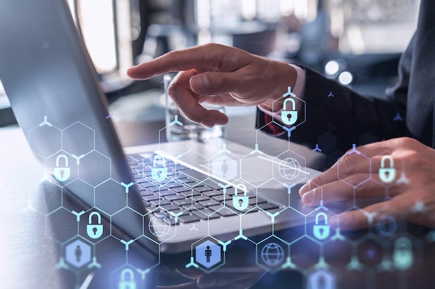 A programmer is typing a code on computer to protect a cyber security from hacker attacks and save clients confidential data Padlock Hologram icons over the typing hands Formal wear