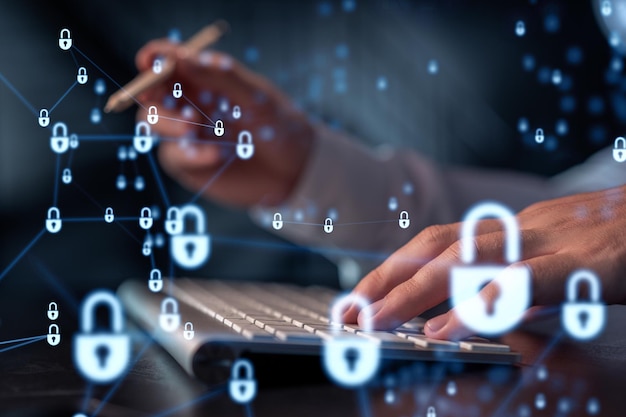 A programmer is typing a code on computer to protect a cyber security from hacker attacks and save clients confidential data Padlock Hologram icons over the typing hands Formal wear