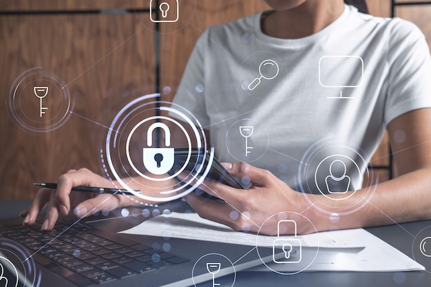 A woman programmer is typing a code on computer to protect a cyber security from hacker attacks and save clients confidential data Padlock Hologram icons over the typing hands Casual wear