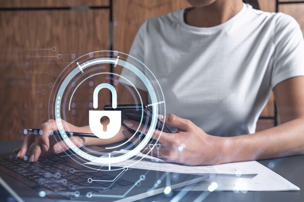 A woman programmer is typing a code on computer to protect a cyber security from hacker attacks and save clients confidential data Padlock Hologram icons over the typing hands Casual wear