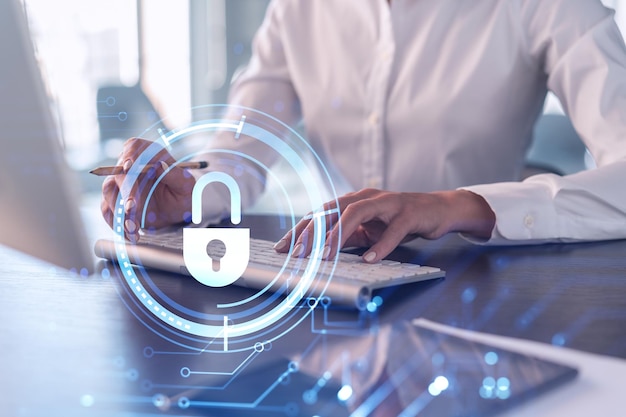 A woman programmer is typing a code on computer to protect a cyber security from hacker attacks and save clients confidential data Padlock Hologram icons over the typing hands Formal wear