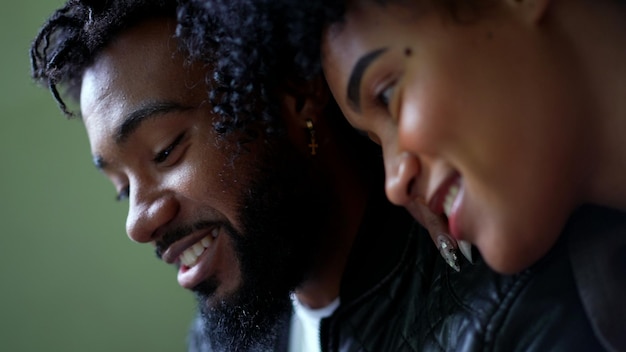 a young black couple looking at phone screen together