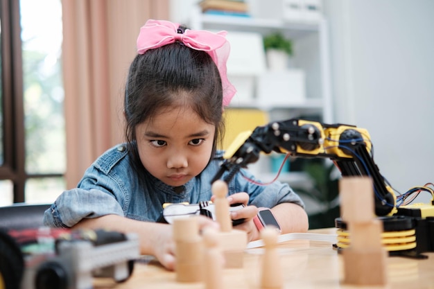 a young girl is playing with a remote control a robot