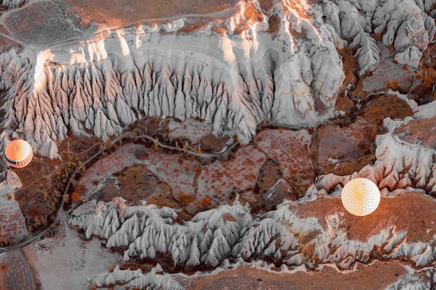 Aerial view of hot air balloons flying above rocky mountains