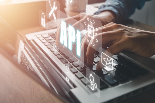 API Application Programming Interface Woman using laptop computer with VR screen API icon on office desk Software development tool modern technology internet and networking concept