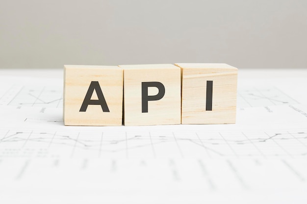 API wooden blocks word on grey background. API short for application programming interface, information concepts.