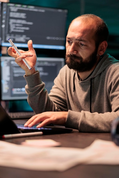 App developer brainstorming ideas about coding solution, finding algorithm to create database script. Feeling pensive and thinking about software developing system late at night.