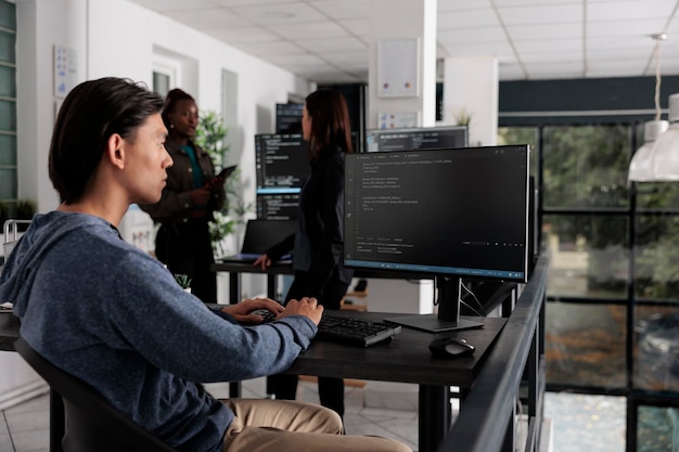 app engineer looking at computer typing machine learning server code, sitting at desk in software company. cloud developer working on database system with coding script in it busy office