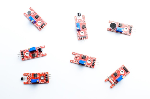 Arduino DIY modules on a white background. Selective focus. Red PCB. Blue potentiometers.