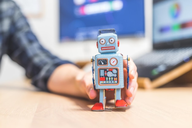 Artificial intelligence concept Toy robot on office desktop Metaphor for chatbot social bot and algorithms