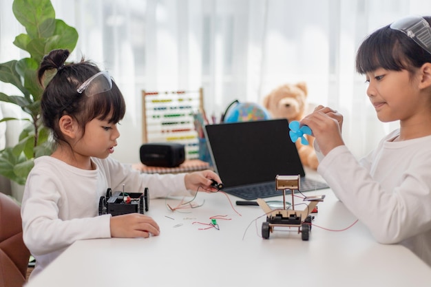 Asia students learn at home in coding robot cars and electronic board cables in STEM STEAM mathematics engineering science technology computer code in robotics for kids concept