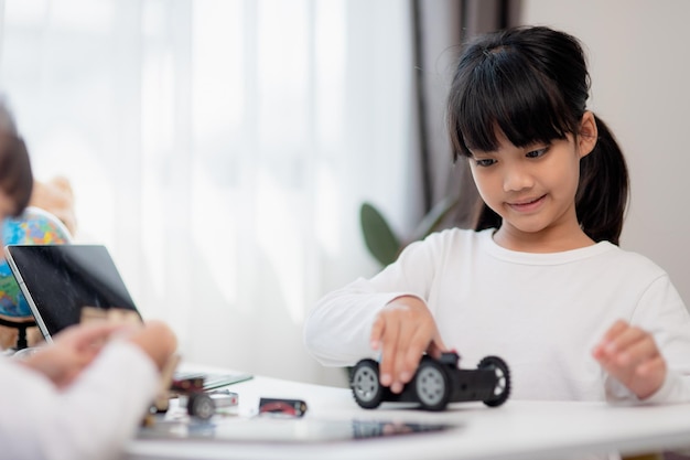 Asia students learn at home in coding robot cars and electronic board cables in STEM STEAM mathematics engineering science technology computer code in robotics for kids concept