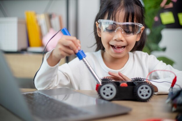 Asia students learn at home in coding robot cars and electronic board cables in STEM STEAM