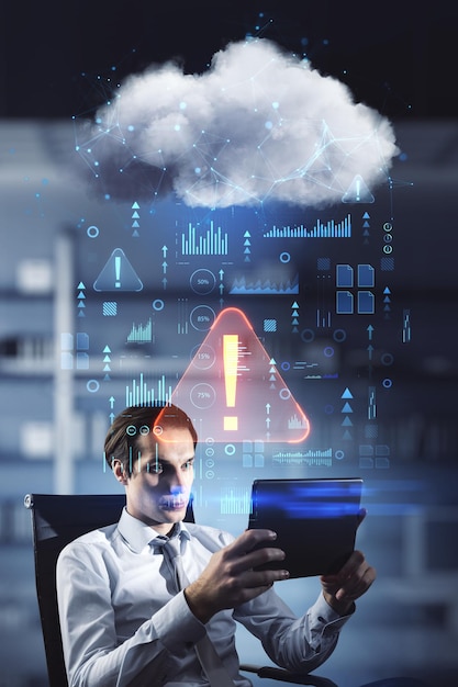Attractive young european businessman with tablet sitting in blurry office interior with abstract hologram raining cloud Data information leak security and theft concept Double exposure