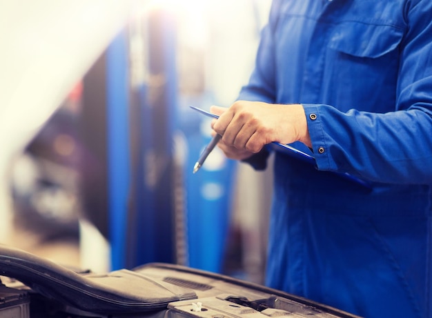 auto mechanic man with clipboard at car workshop