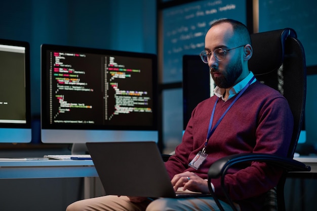 Bearded Man using Laptop at Office with Blue Light