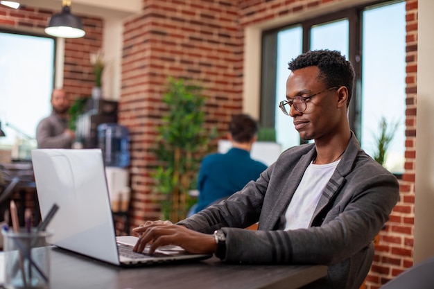 Black man uses laptop in startup office