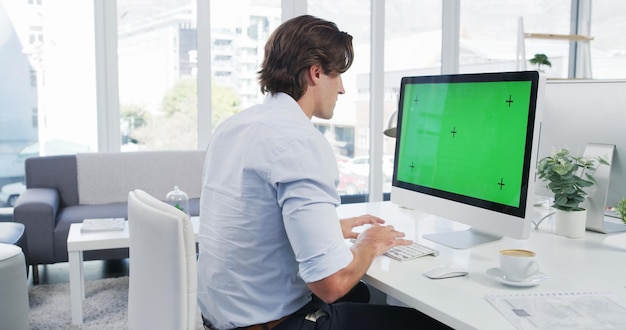 Business man computer and green screen on monitor mockup in office with web designer and programmer Desk project and website development with digital research and software with tracking marker