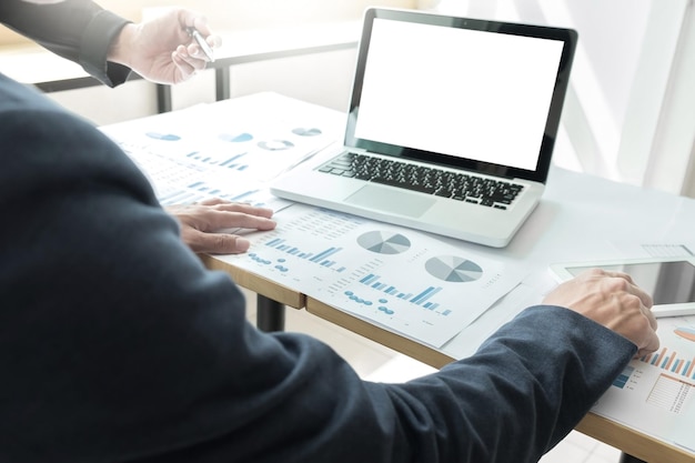 Business people discussing over graphs at desk