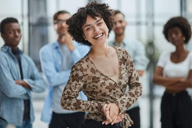 business woman with her staff in background at office