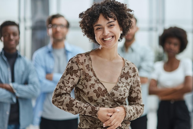 business woman with her staff in background at office