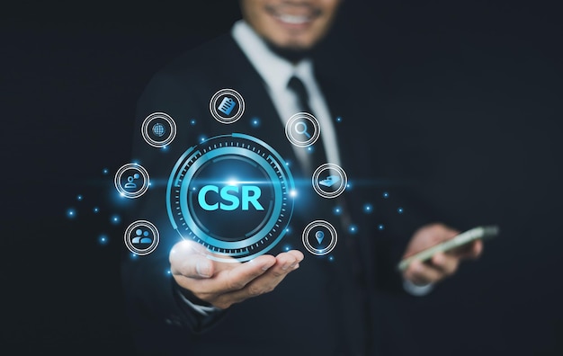 businessman holding csr icon concept in the hand for business and organization corporate social responsibility and giving back to the community on a green nature csr