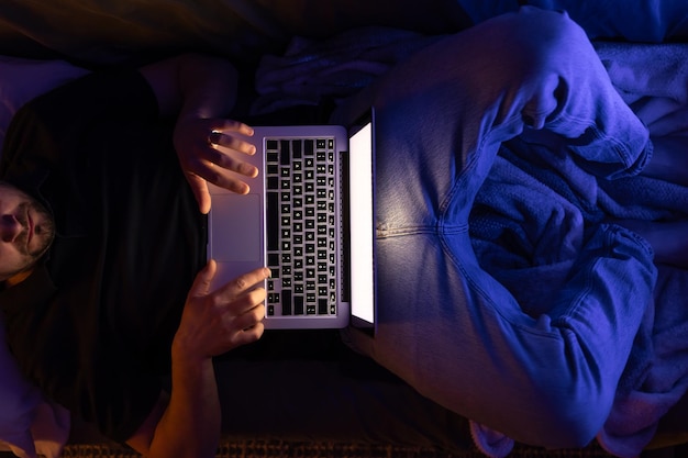 Businessman or freelancer working overtime with laptop lying on late at night