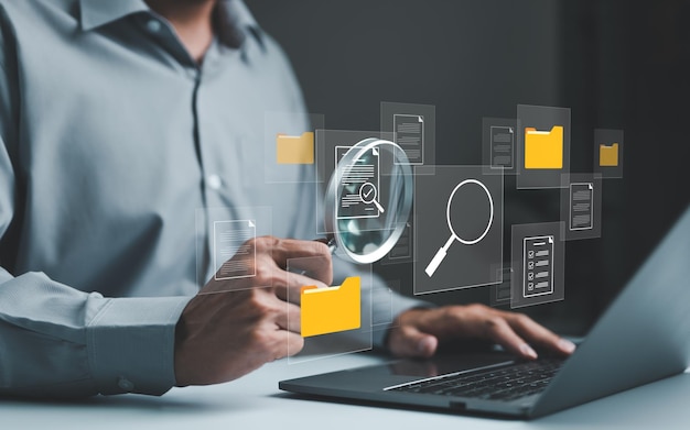 Businessman using computer to manage document files in folders folder file storage on cloud share database online software for archiving and company data DMS Document management system concept