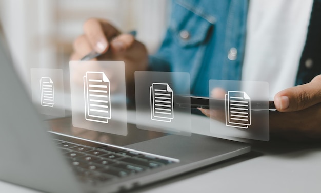 Businessman using laptop to document management with icons on virtual screen ERP document management concept