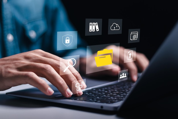 Businessman using laptop with virtual document management system for online document database and automated processes in file management Search and manage document database files online
