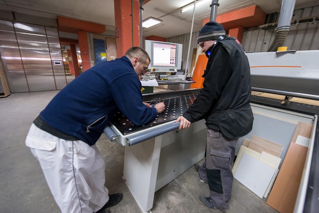 carpenters calculating and programming a cnc wood working machine