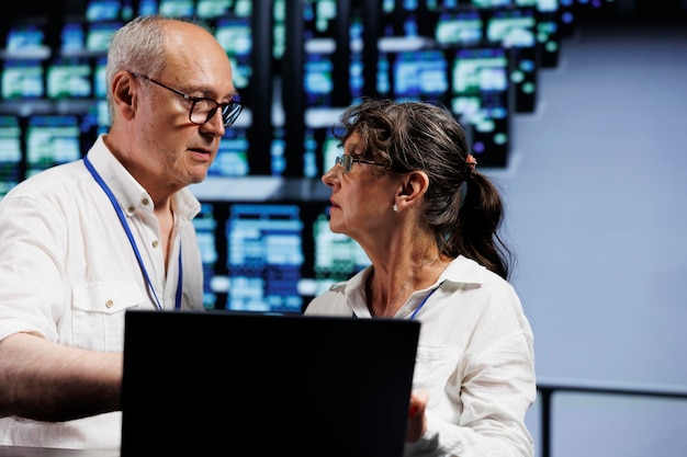 Certified aged developers working to maintain uptime in high tech facility. Trained IT programmers brainstorming solutions to data center server cabinets crashing, trying to fix components