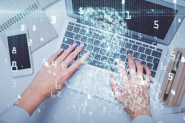 Chồng ảnh đôi bàn tay người phụ nữ đang làm việc trên máy tính và bản vẽ hologram chủ đề dữ liệu. Góc nhìn từ trên xuống về khái niệm công nghệ