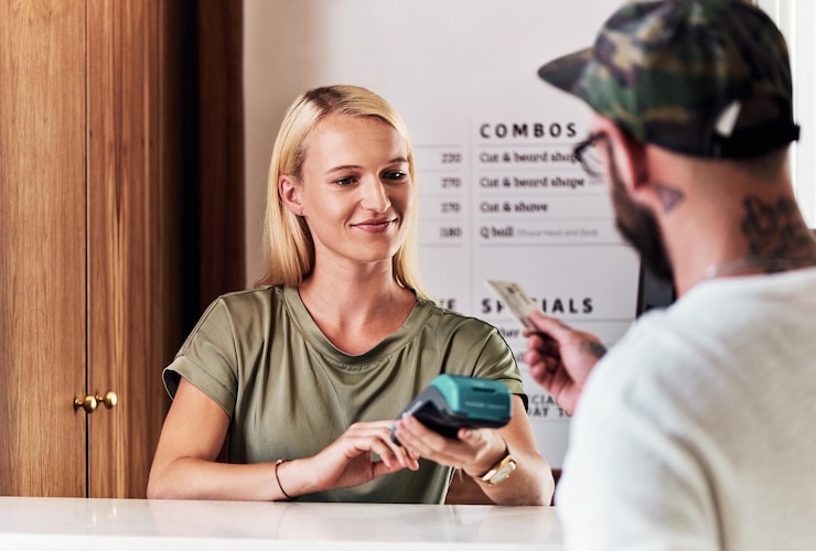 Photo client woman and credit card machine in salon for payment transaction or hair service barbershop customer man and hairstylist with nfc technology for haircut makeover or grooming point of sale