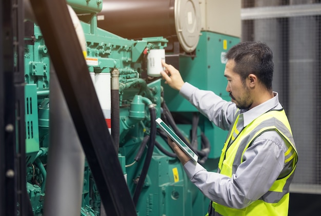 Close up hand of engineer or electrician man working check the electrical system with tablet at factory.