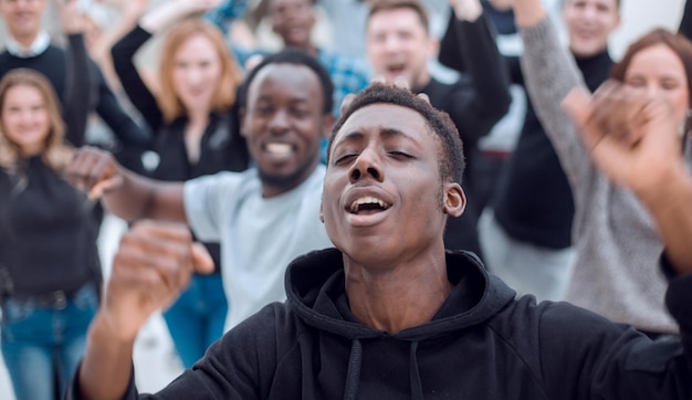 close up . happy guy against the background of a cheering group of young people