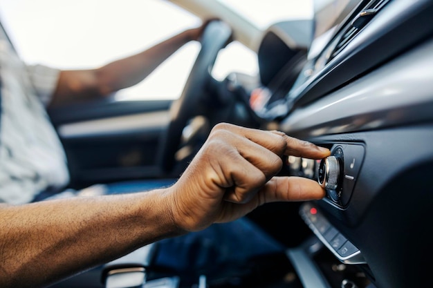 close up of black driver39s hand turning up radio in a car