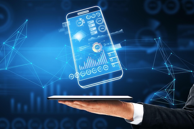 Close up of businessman hand holding digital blue smartphone with business chart on dark polygonal background Analytics financial report and money concept