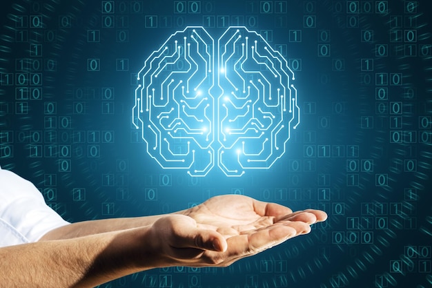 Close up of businessman hands holding glowing brain hologram with binary coding on blue background Programming machine learning and artificial intelligence concept