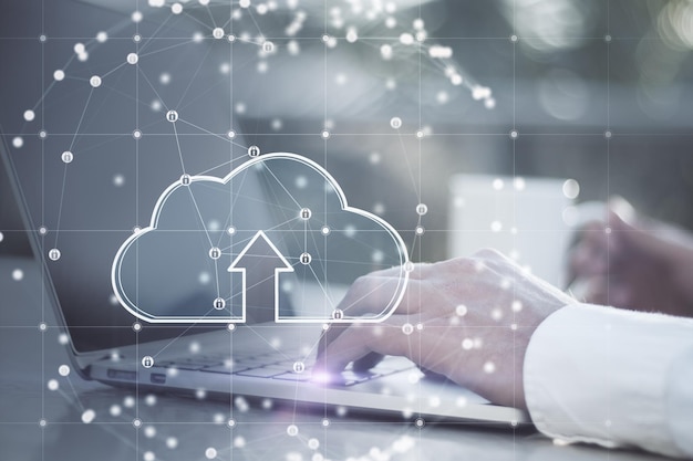 Close up of businessman hands using laptop at desktop with coffee cup and glowing cloud inside sphere connections on blurry outdoor background Data storage and technology concept Double exposure