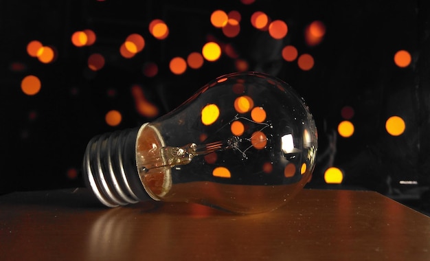 Close-up of illuminated light bulb on table