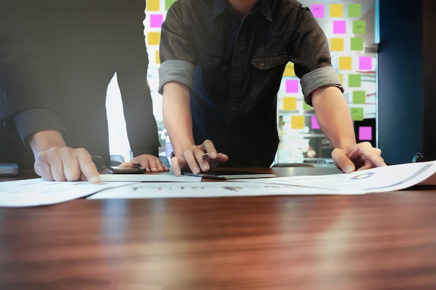 Close-up of men with paper on table