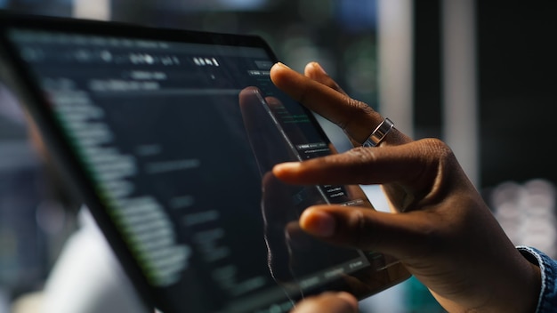 Close up of server room programmer checking coding on tablet enhancing operational efficiency and