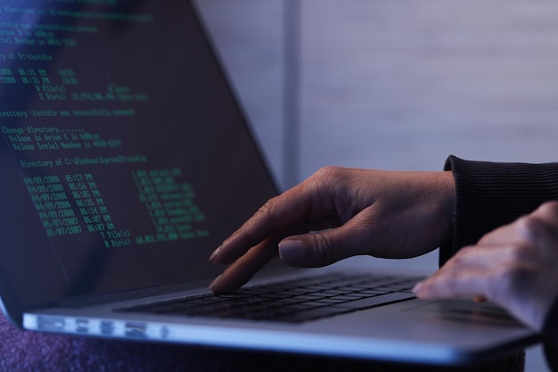 Close up of unrecognizable computer hacker stealing computer software while using laptop