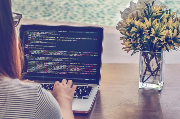 Close-up of woman using laptop at table