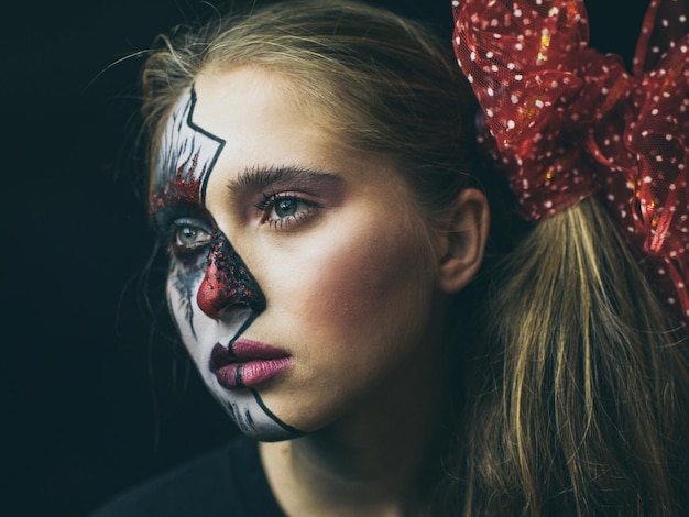 close-up of woman with painted face against black background