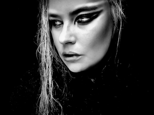 close-up of young woman with long hair against black background