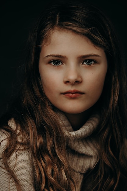 close-up portrait of cute girl against black background