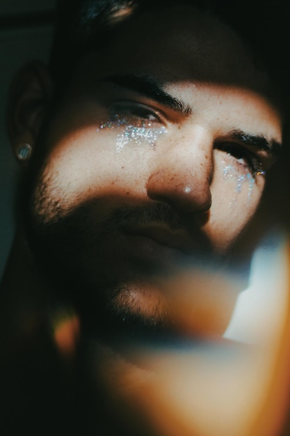 close-up portrait of man with facepaint in darkroom