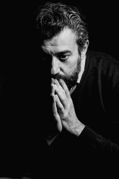 close-up thoughtful man against black background